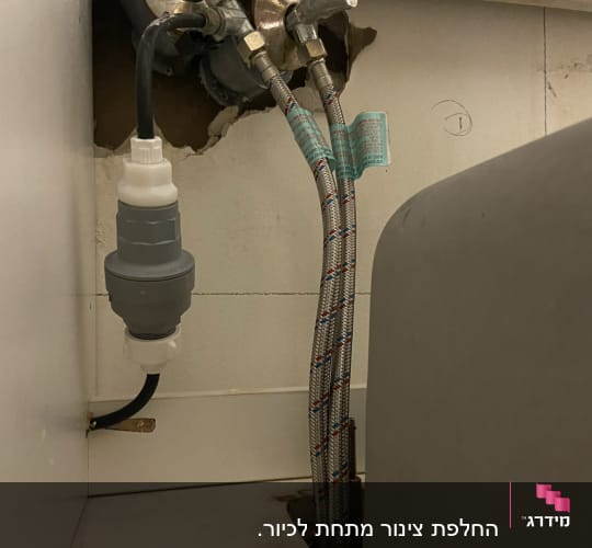 צינורות מים מחוברים לברזים בקיר עם חיבורים מתכתיים